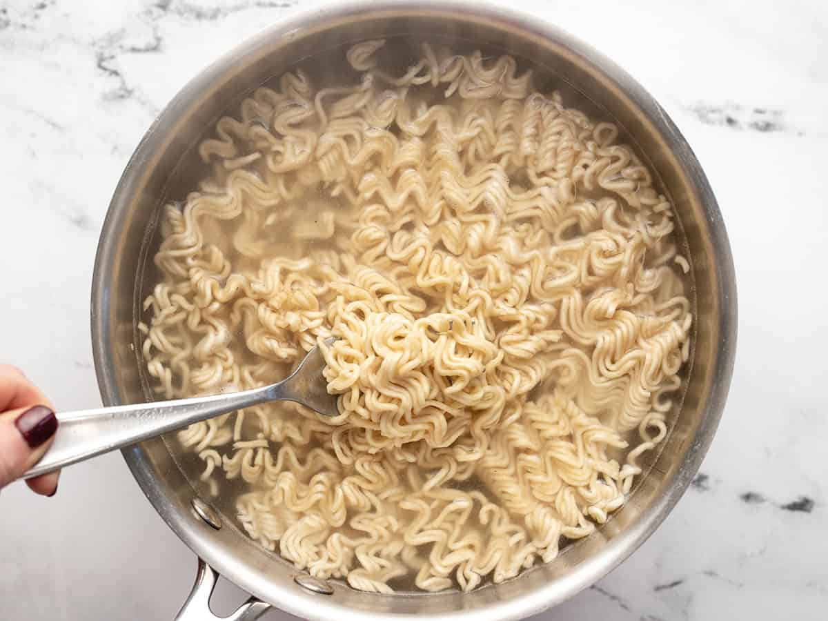 Partially cooked instant ramen in a pot. 