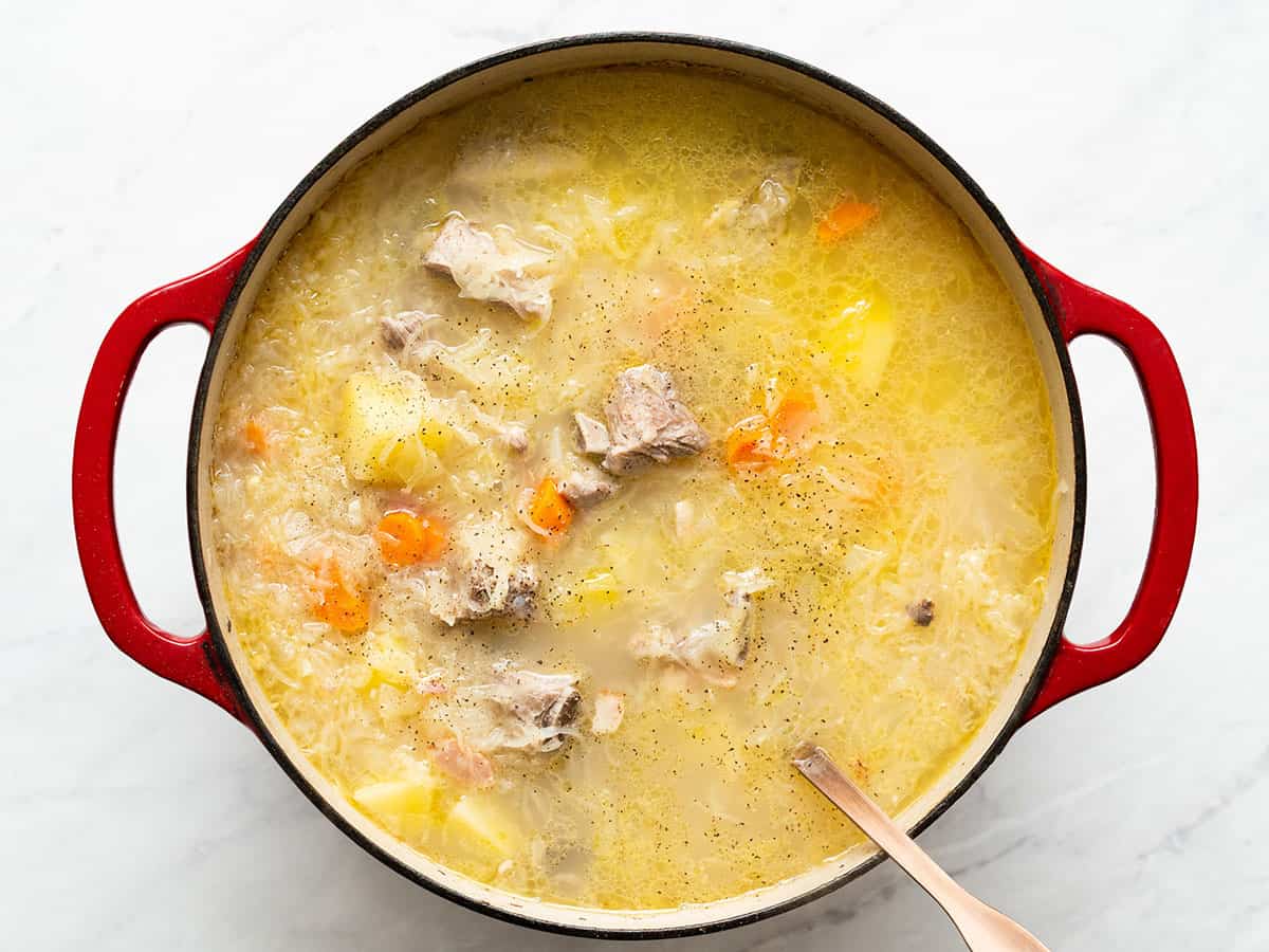 Finished sauerkraut soup with a wooden spoon.