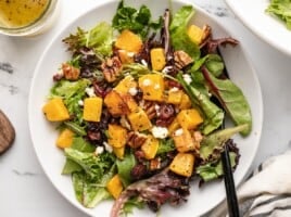 Close up overhead shot of one serving of butternut squash salad in a bowl.