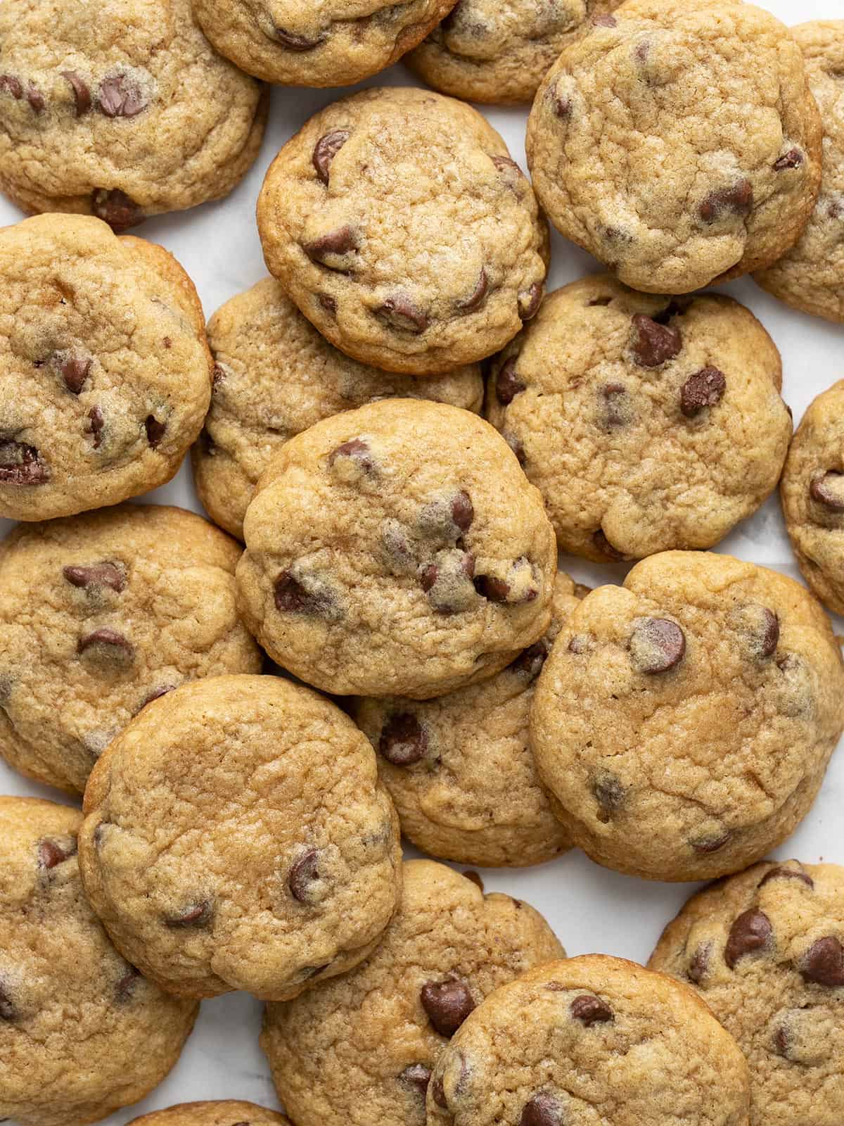 Overhead view of a lot of chocolate chip cookies in a pile.