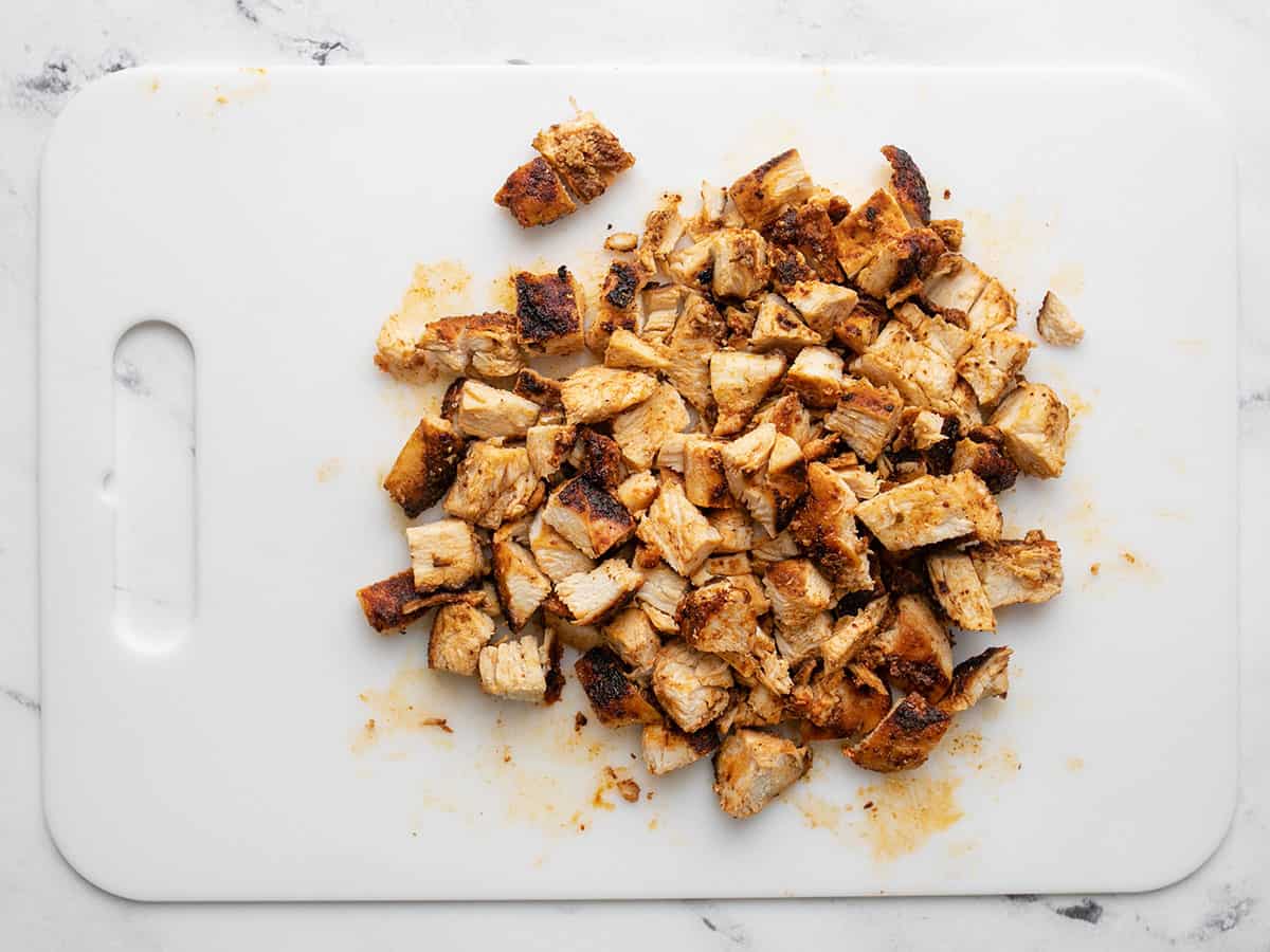 Overhead shot of chopped chicken breast on a white cutting board.