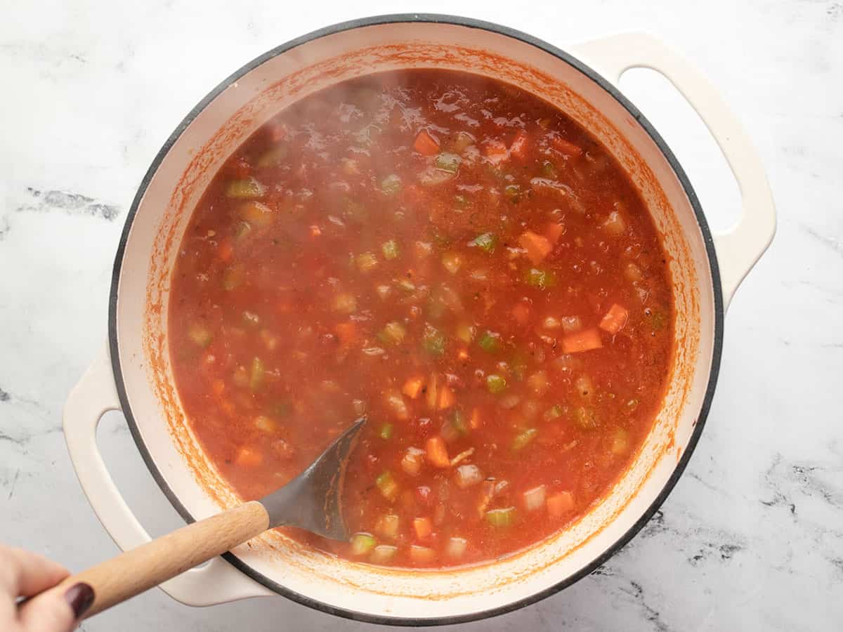 Large pot filled with pasta e fagioli soup simmering to cook before adding the final ingredients. 