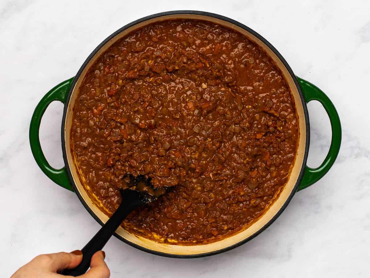 Simmered bolognese sauce being stirred in the pot. 