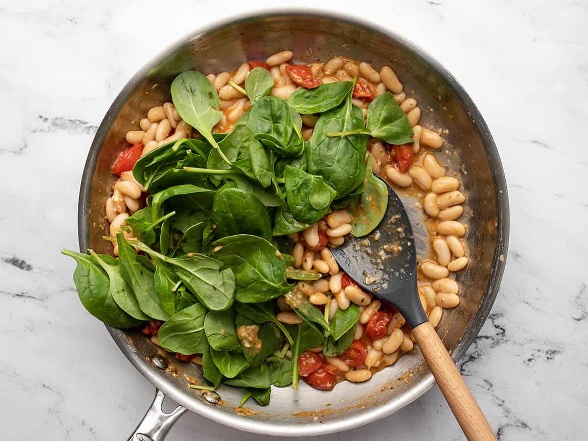 Fresh spinach added to the skillet.