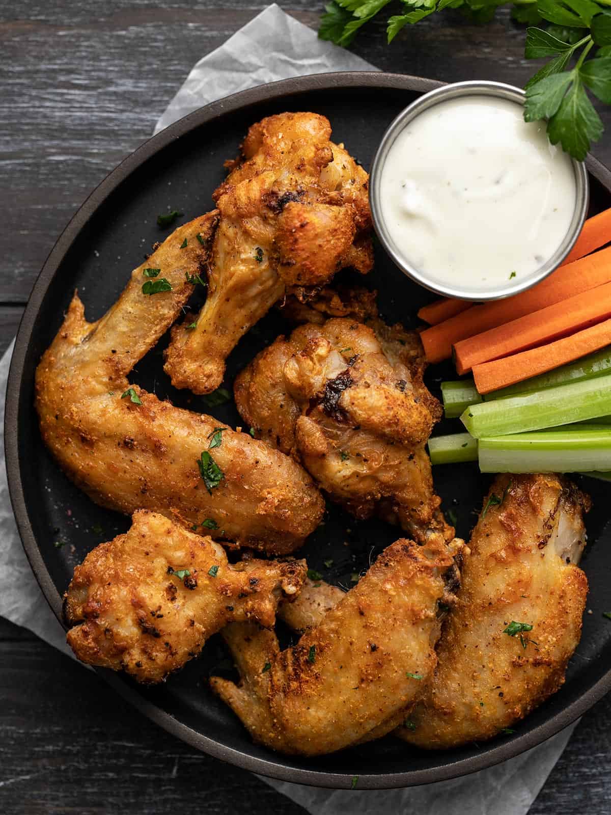 Overhead shot of air fryer chicken wings on a black plate.