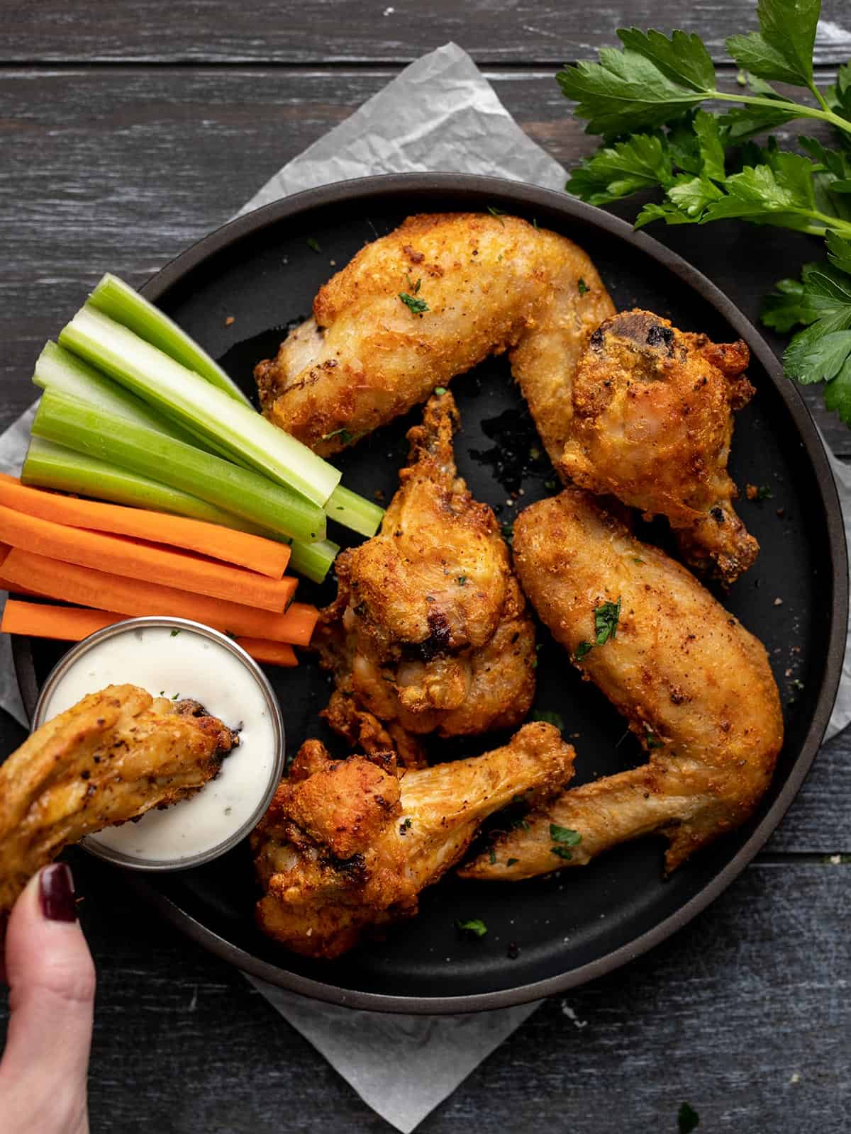 Overhead shot of air fryer chicken wings on a black plate.