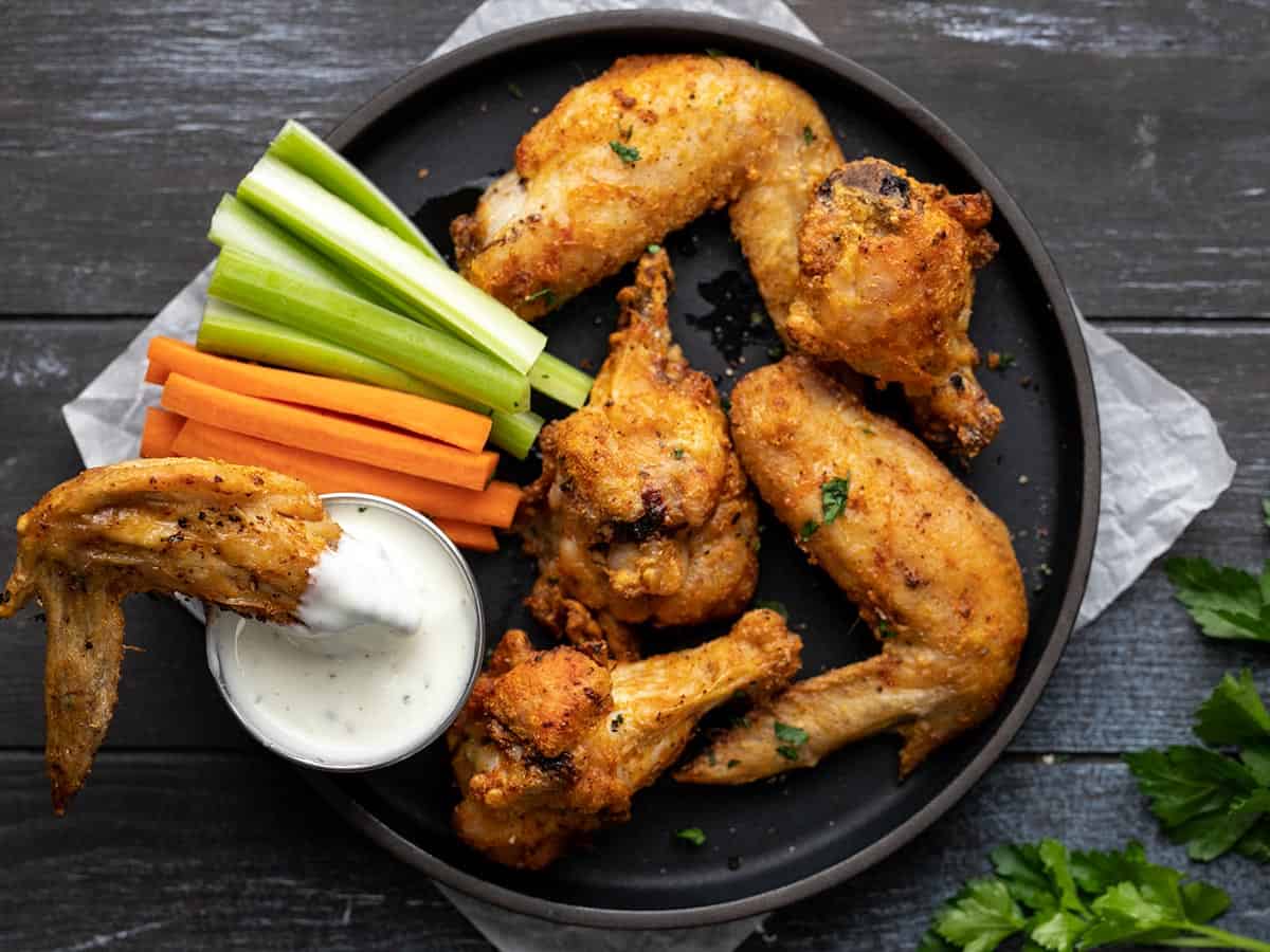 Overhead shot of air fryer chicken wings on a black plate.