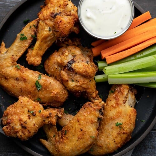 Overhead shot of air fryer chicken wings on a black plate.