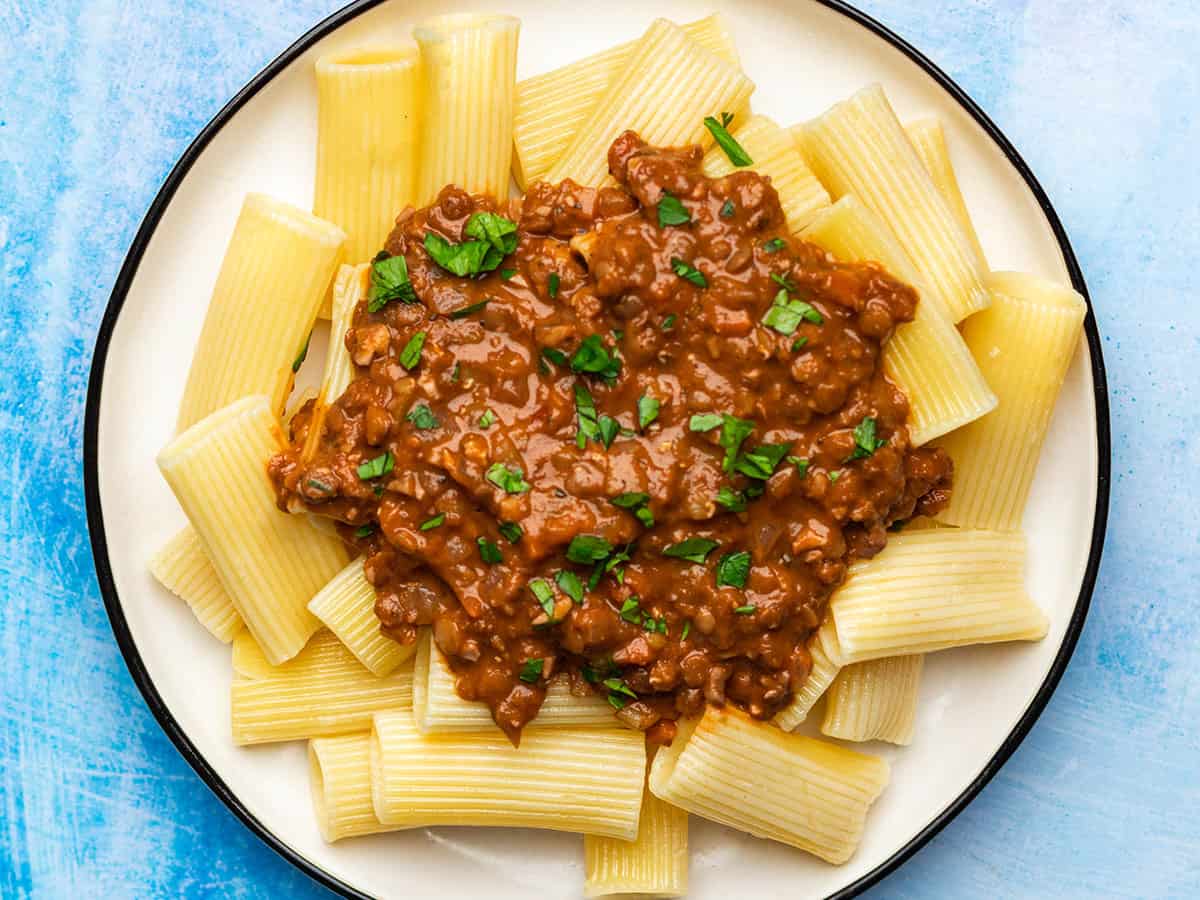 Overhead view of a plate of pasta with lentil bolognese on top. 