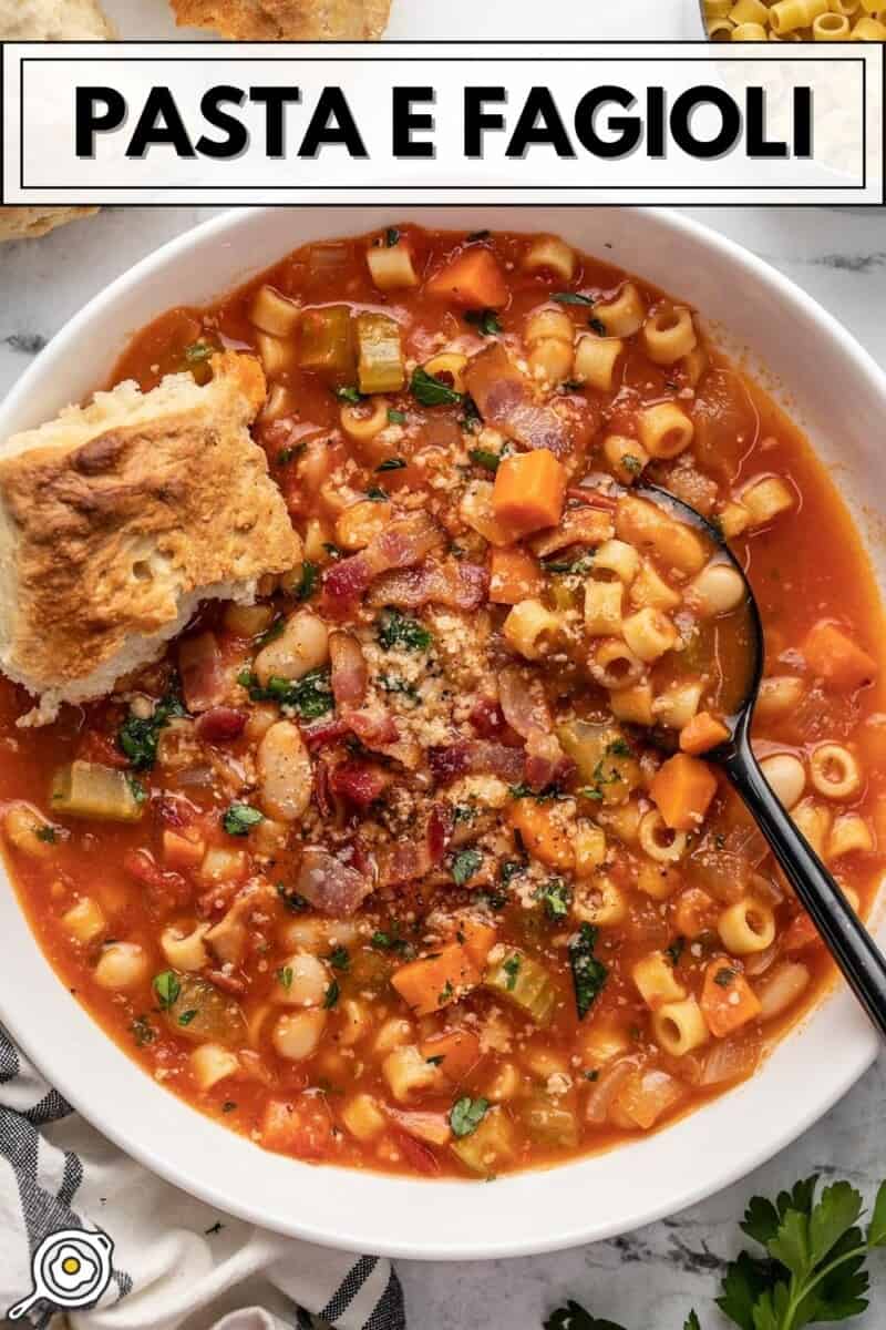 Close up overhead view of a bowl of pasta e fagioli with a piece of bread in the bowl.