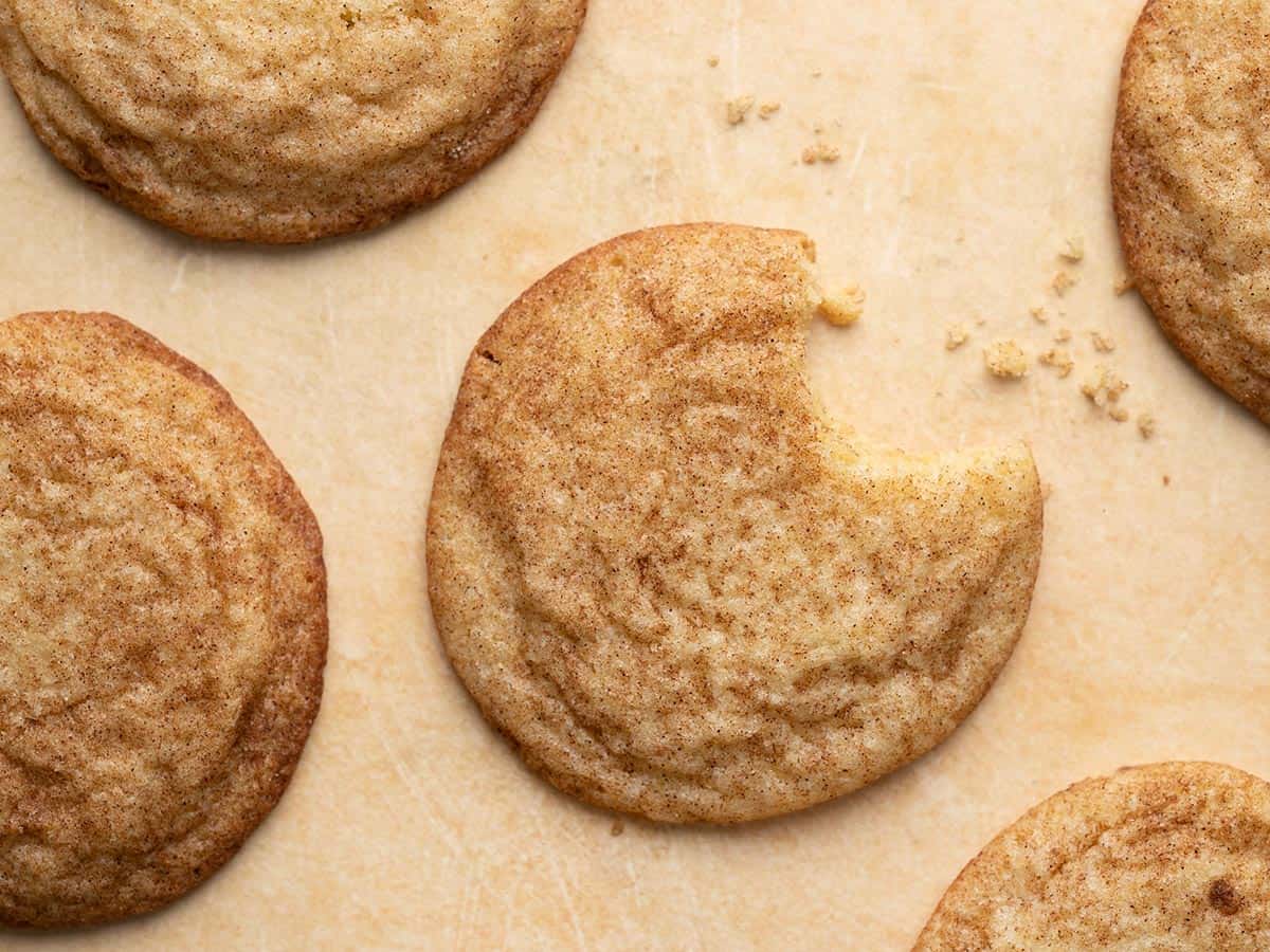 Overhead shot of snickerdodle cookies, with one cookie with a bite taken out of it.