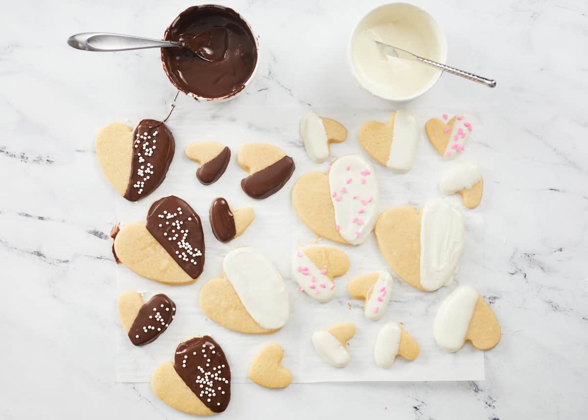 Overhead shot of Valentine's Day cookies dipped in white and milk chocolate and decorated with sprinkles.