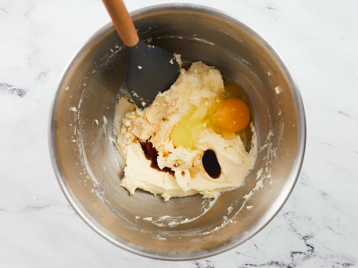 Overhead shot of egg and vanilla being mixed into butter.