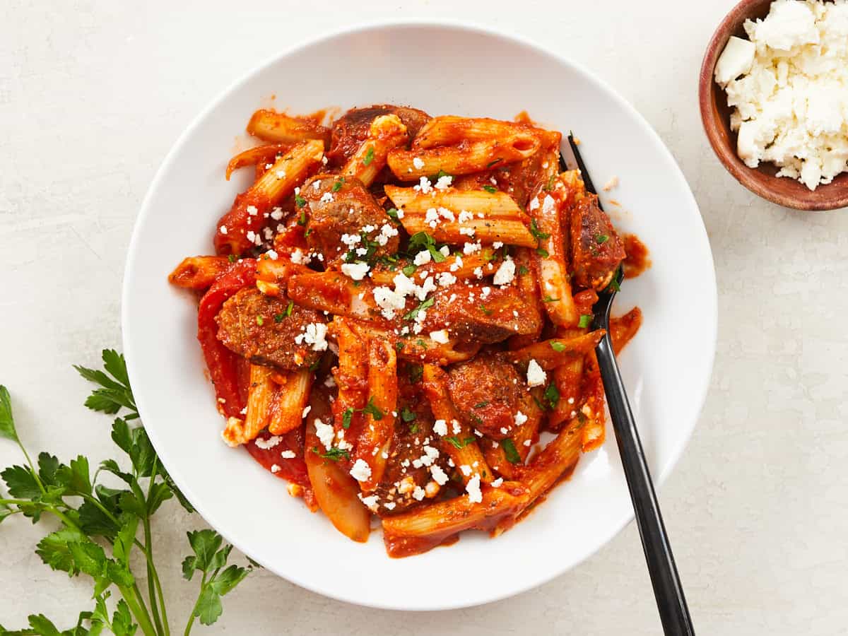 Overhead view of a bowl full of pasta with sausage and peppers.