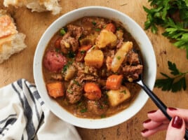 Overhead view of a bowl of beef stew with a spoon.