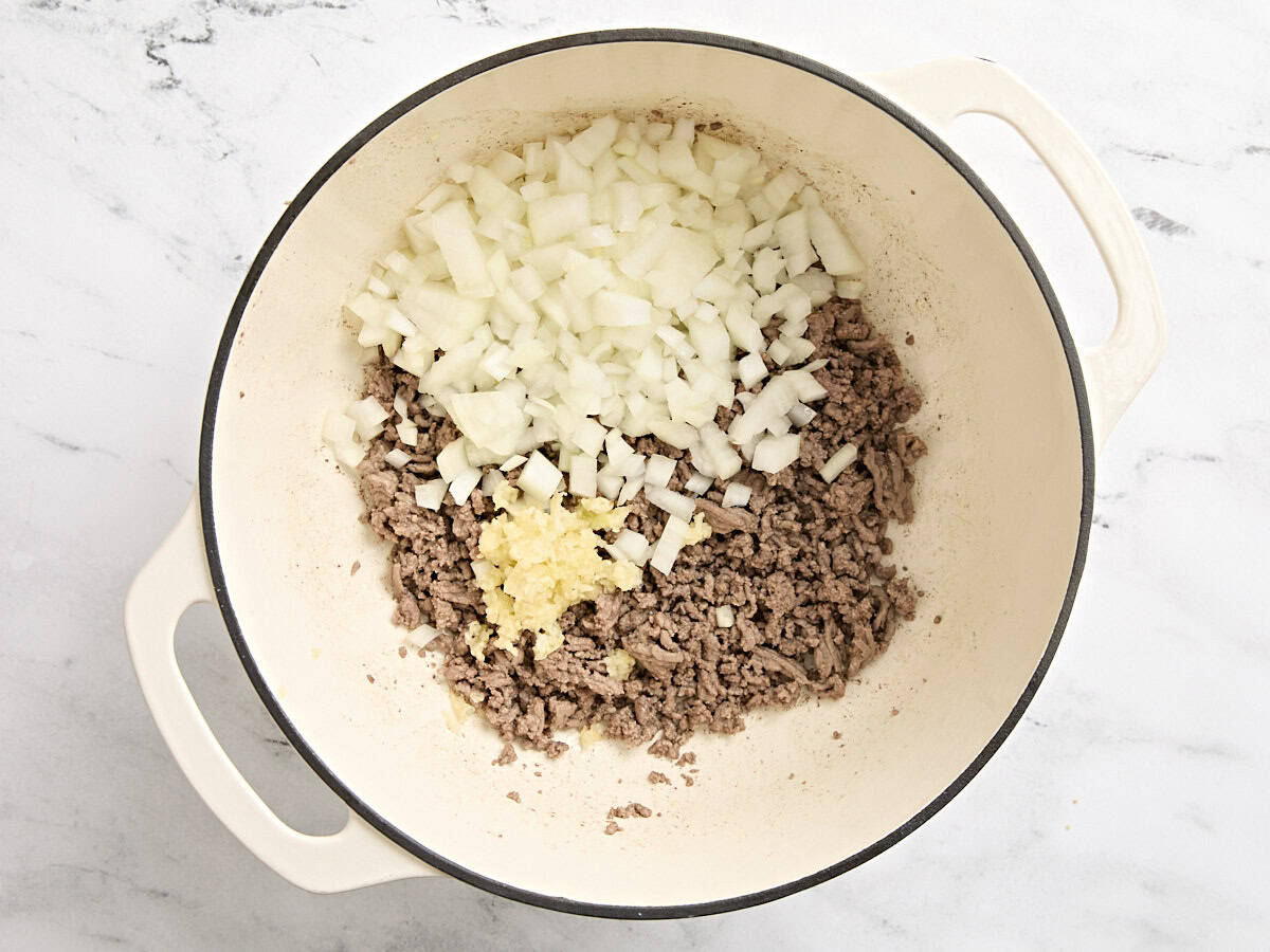 Browned ground beef, onions, and minced garlic in a dutch oven.