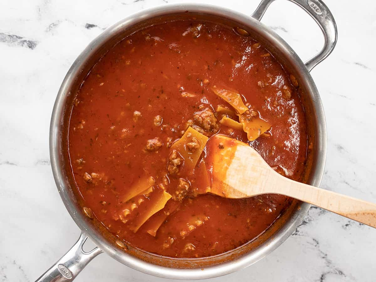 Noodles added to the sauce in the skillet.