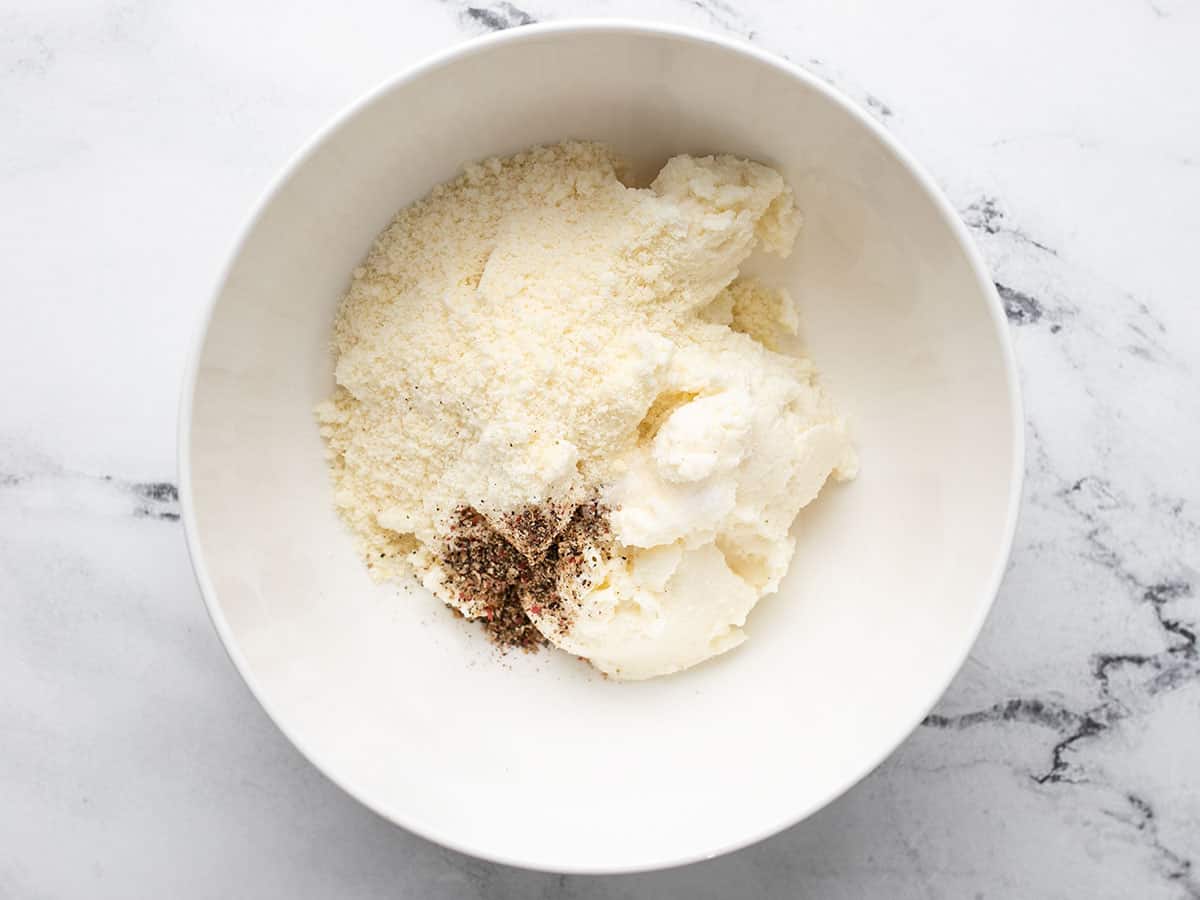 Ricotta, Parmesan, salt, and pepper in a bowl.