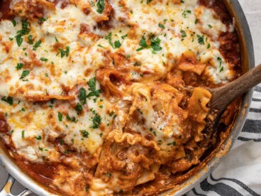 Close up of skillet lasagna being scooped out of the skillet.