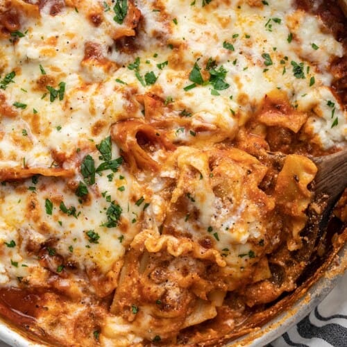 Close up of skillet lasagna being scooped out of the skillet.