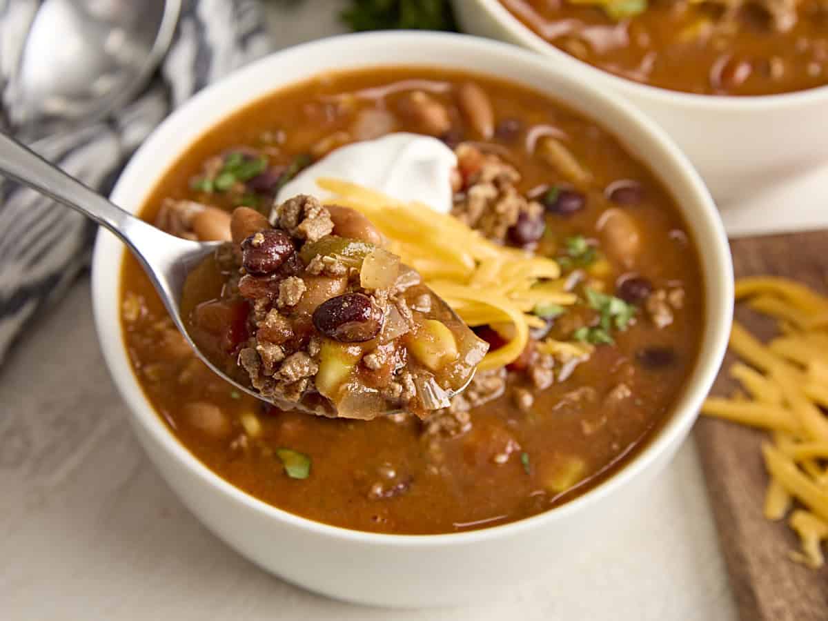 Side view of a bowl of taco soup, with some on a spoon.