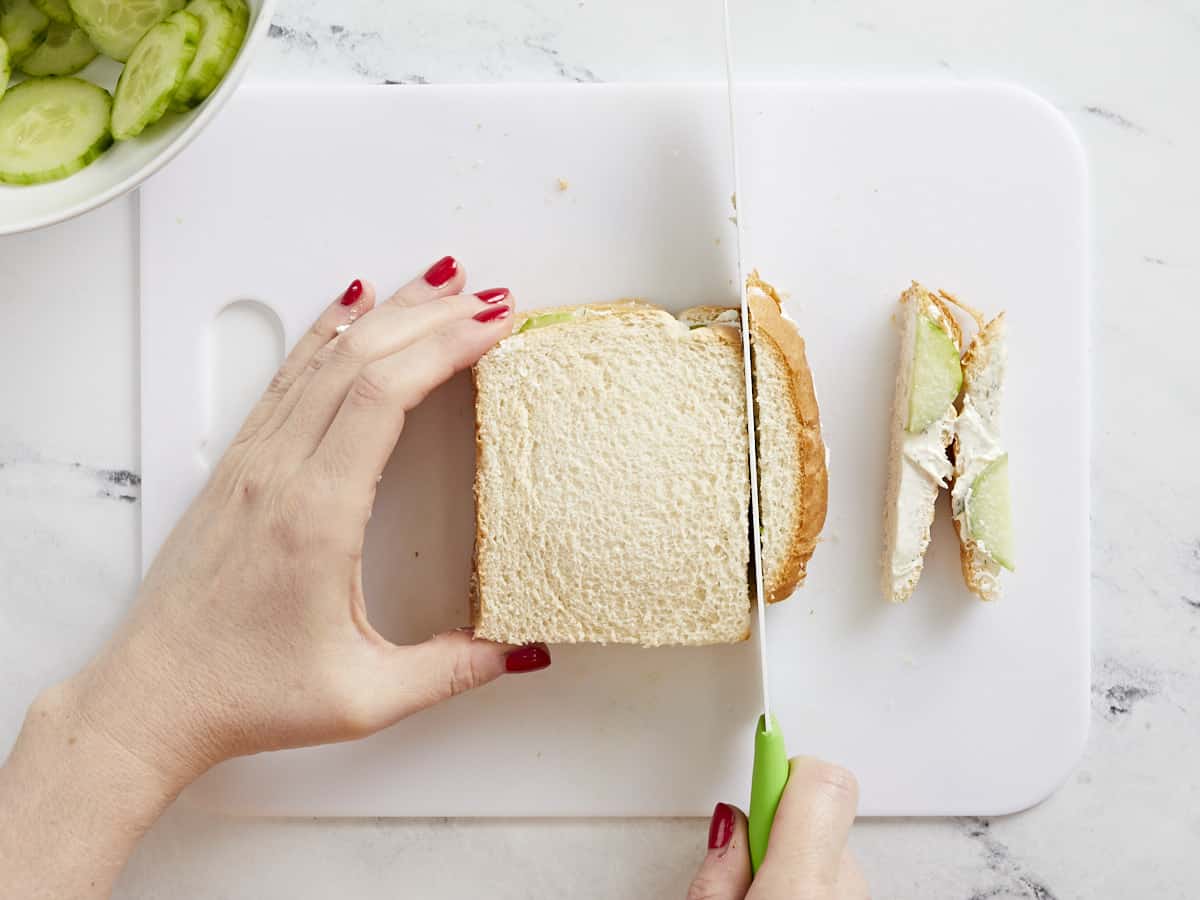 Crusts being sliced off the sandwich.