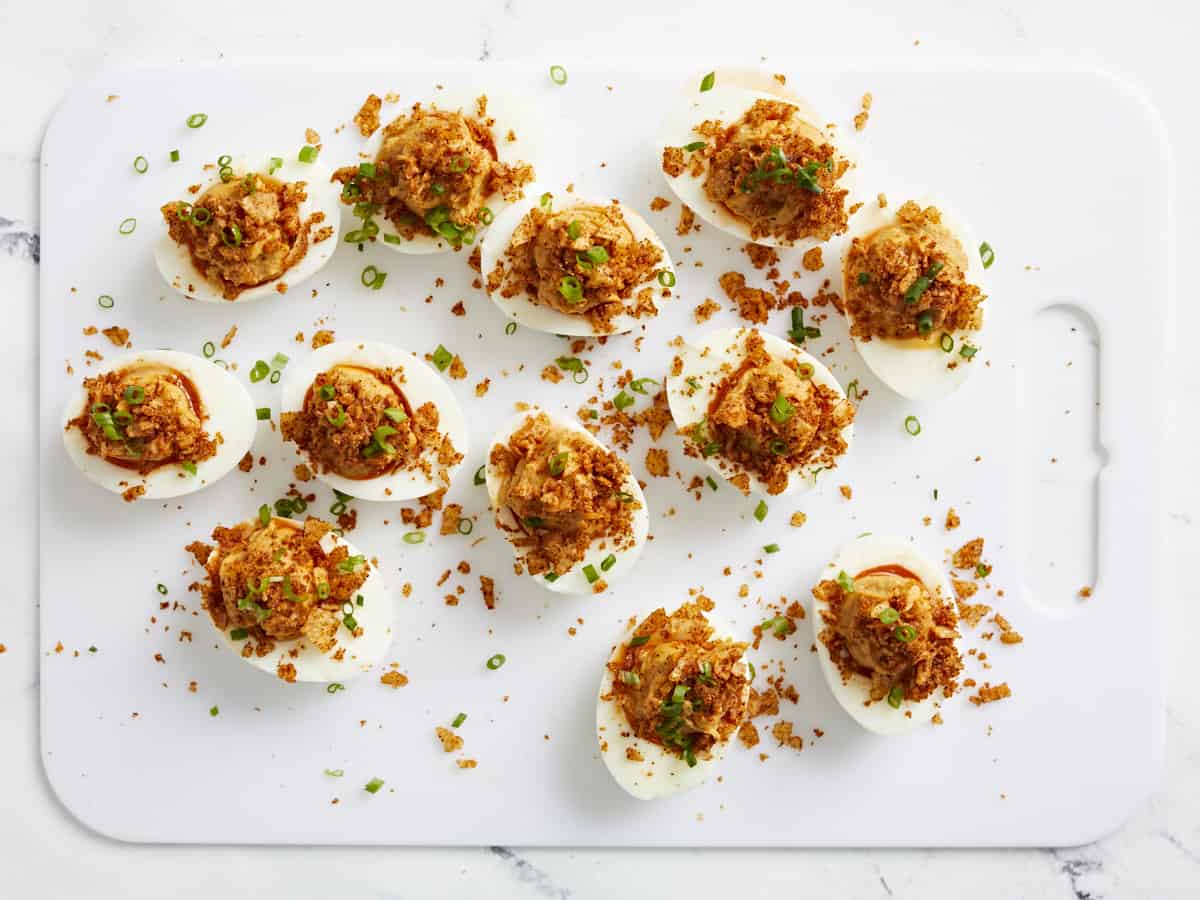 Overhead shot of finished Nashville Hot Deviled Eggs on white cutting board.