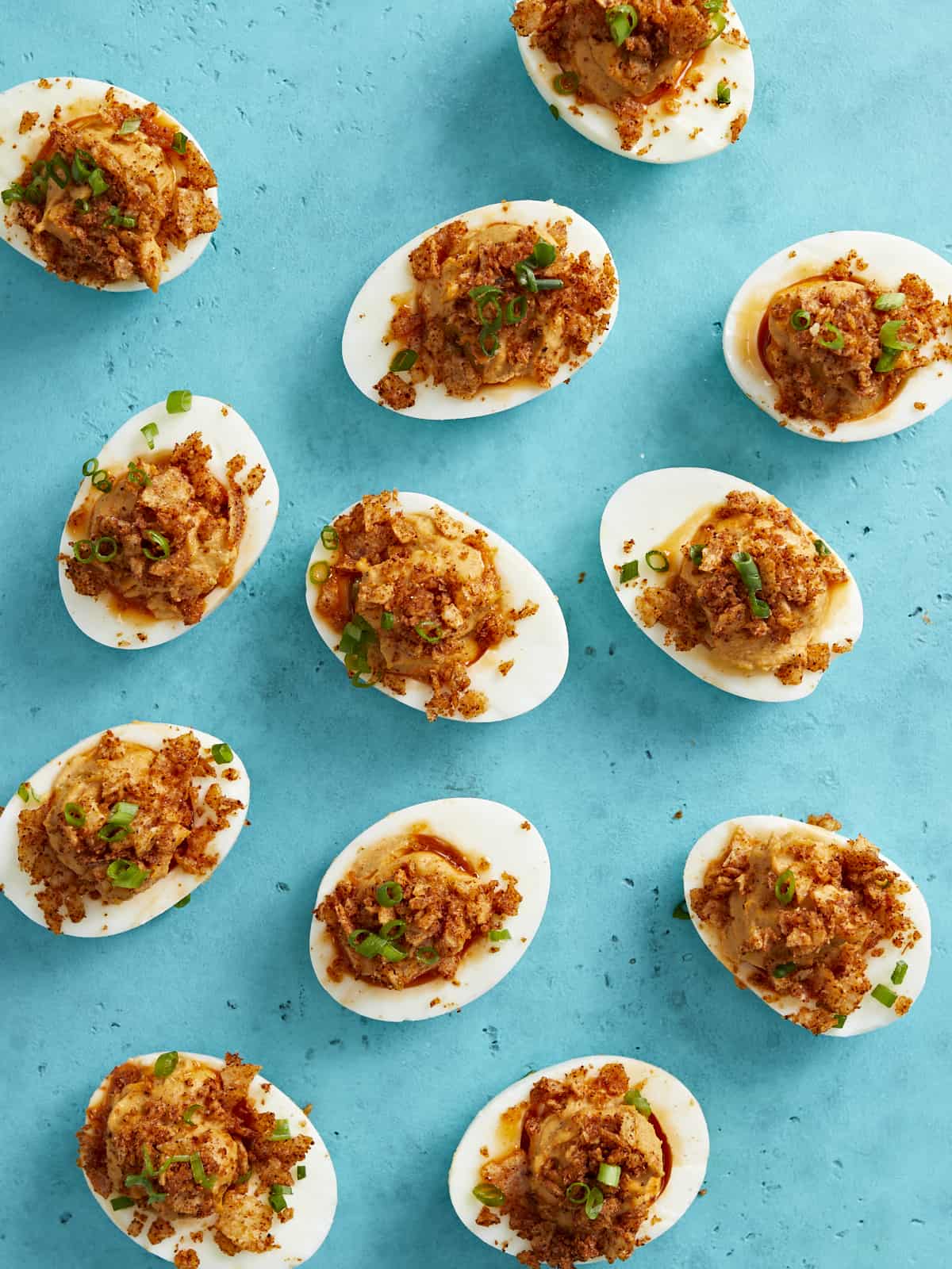 Overhead shot of Nashville Hot Deviled Eggs on aqua background.