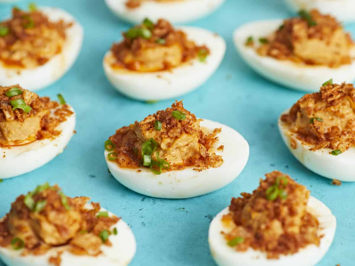 Side shot of Nashville Hot Deviled Eggs on aqua background.