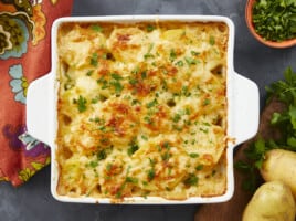 Overhead shot of scalloped potatoes in a white casserole dish.