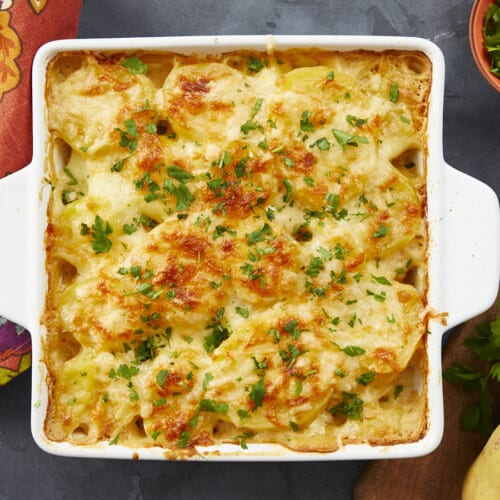 Overhead shot of scalloped potatoes in a white casserole dish.