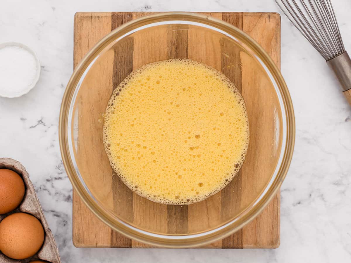 Eggs whisked in a small glass bowl.