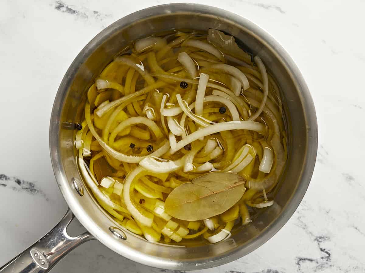 Overhead shot of Yuca En Escabeche in a silver pot.