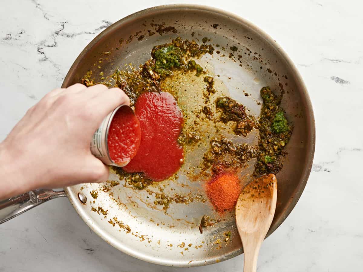 Tomato sauce and seasoning added to the skillet.