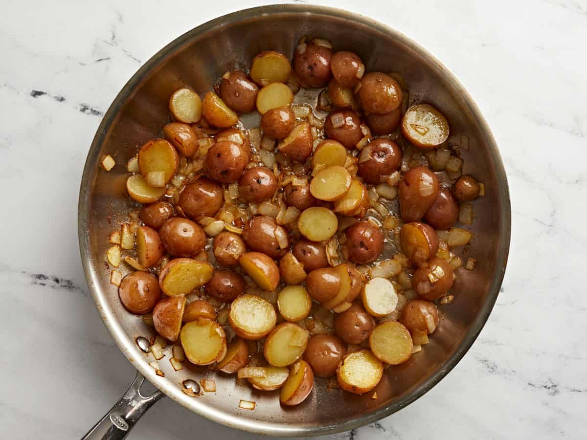 Potatoes added back to the skillet with the onions.