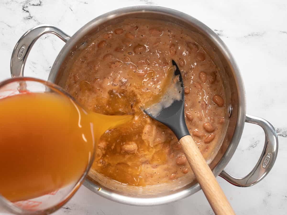 Vegetable broth being poured into the pot.