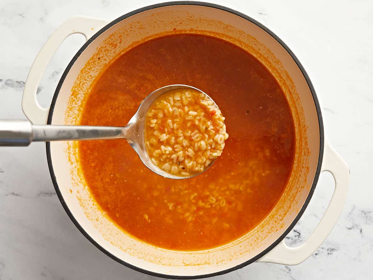 Finished Sopa de Letras being lifted out of the pot with a ladle. 