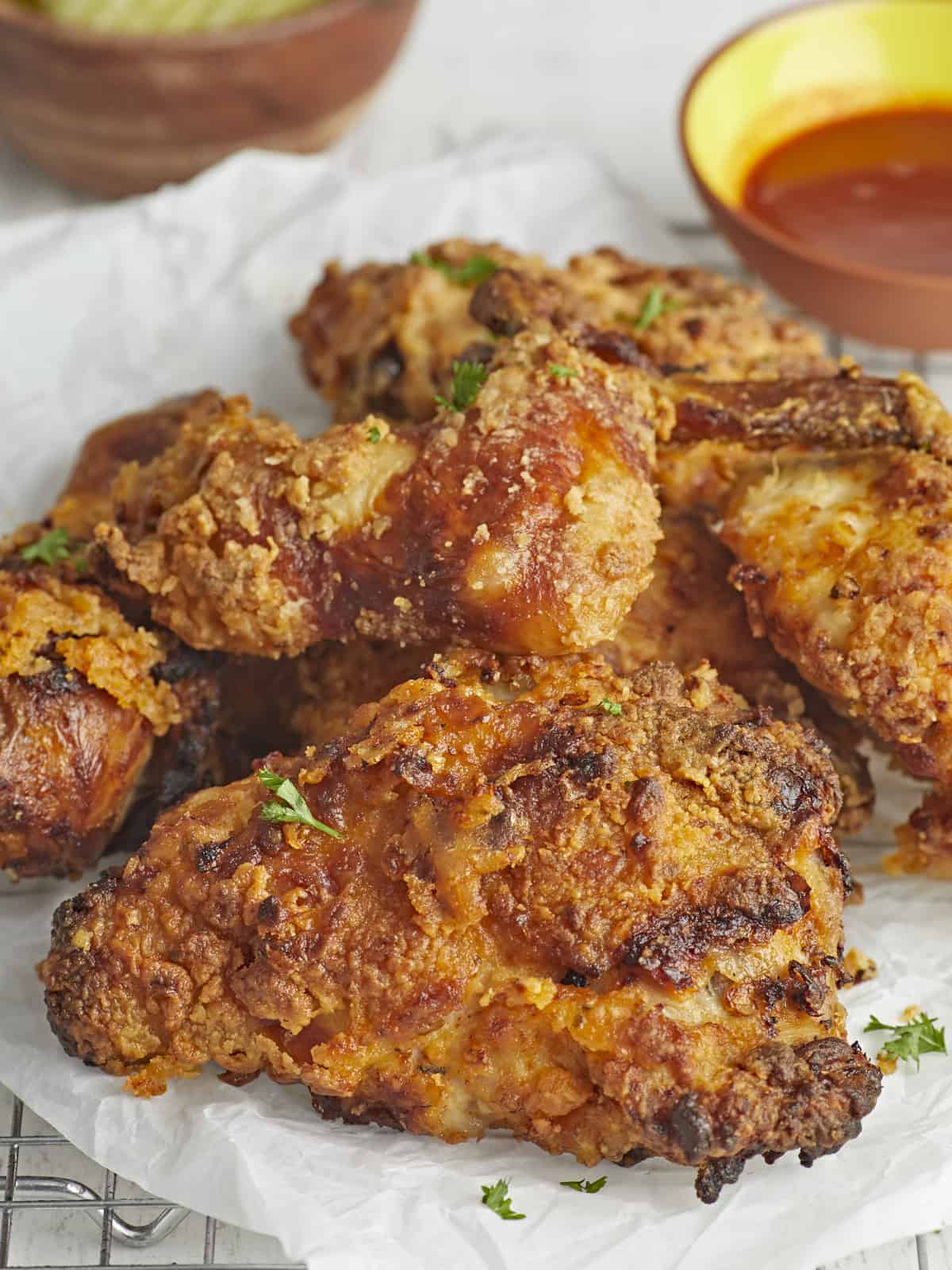 Side shot of air fryer fried chicken on parchment paper.