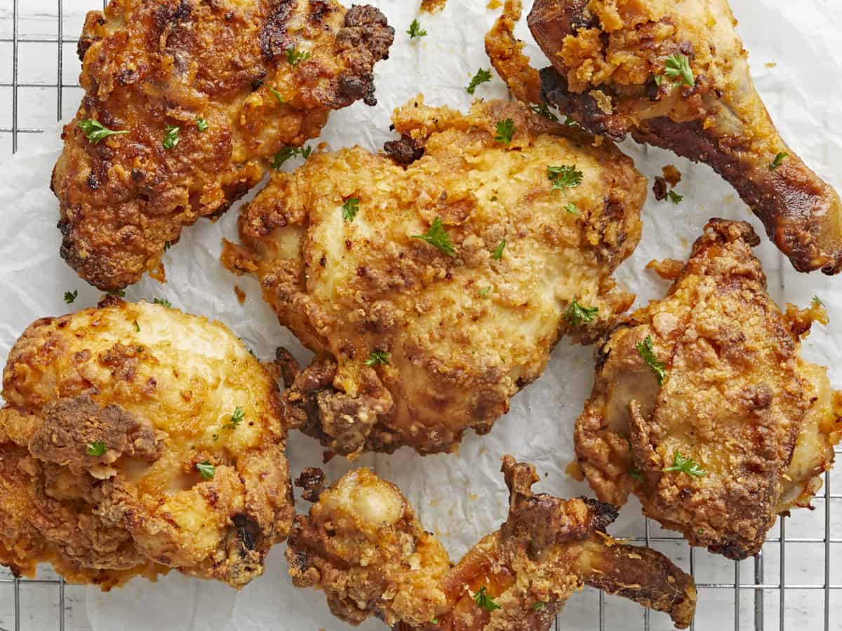 Overhead close up view of Air Fryer Fried Chicken on parchment paper and a cooling rack.