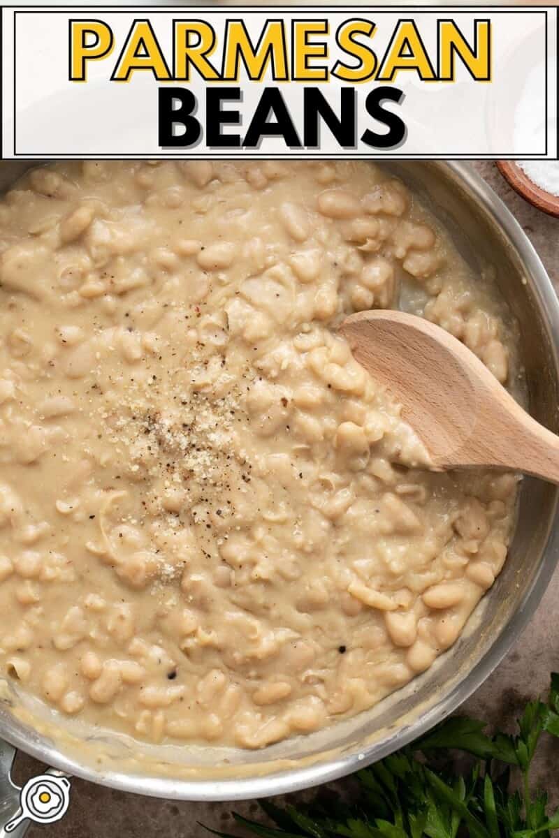 Overhead view of Parmesan beans in the skillet with a wooden spoon.