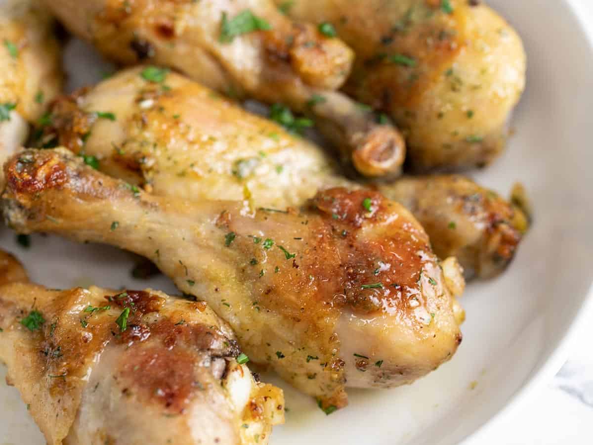 Close up side view of ranch chicken drumsticks in a bowl.