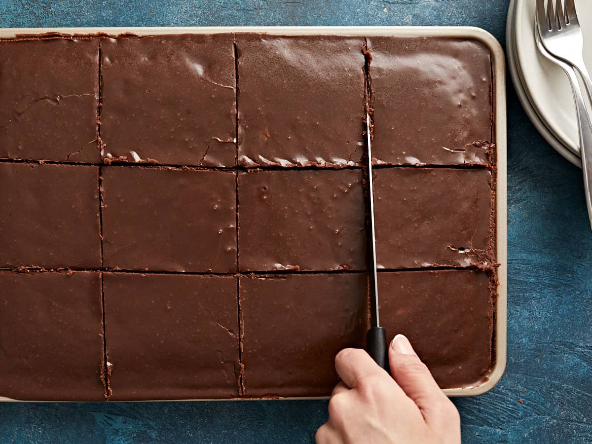 A Texas Sheet Cake being cut into slices.