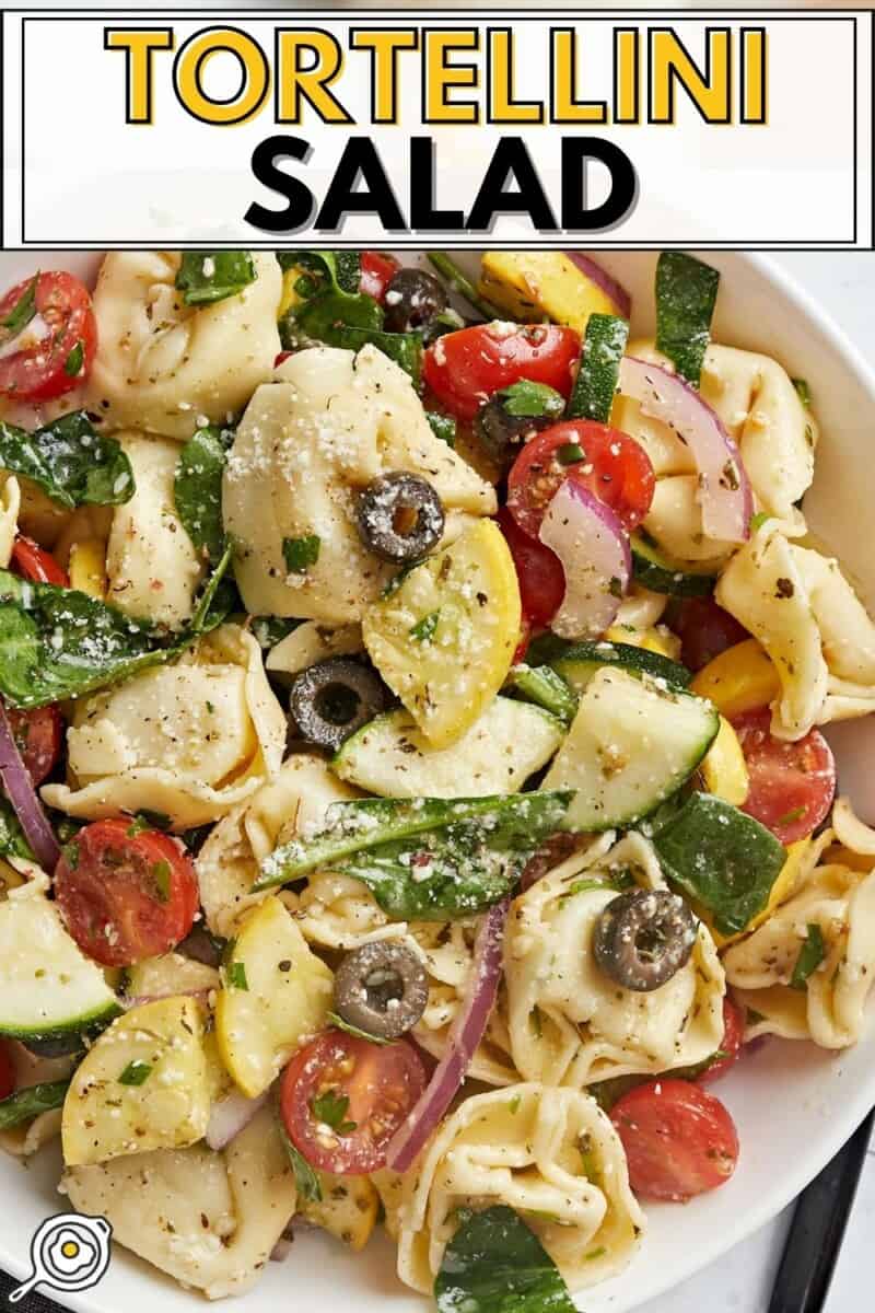 Overhead shot of tortellini salad in a white bowl.