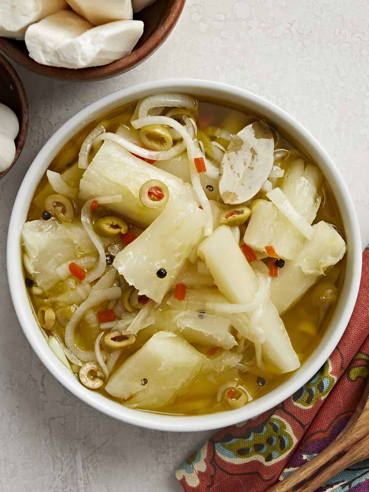 Overhead shot of Yuca En Escabeche in a white bowl.