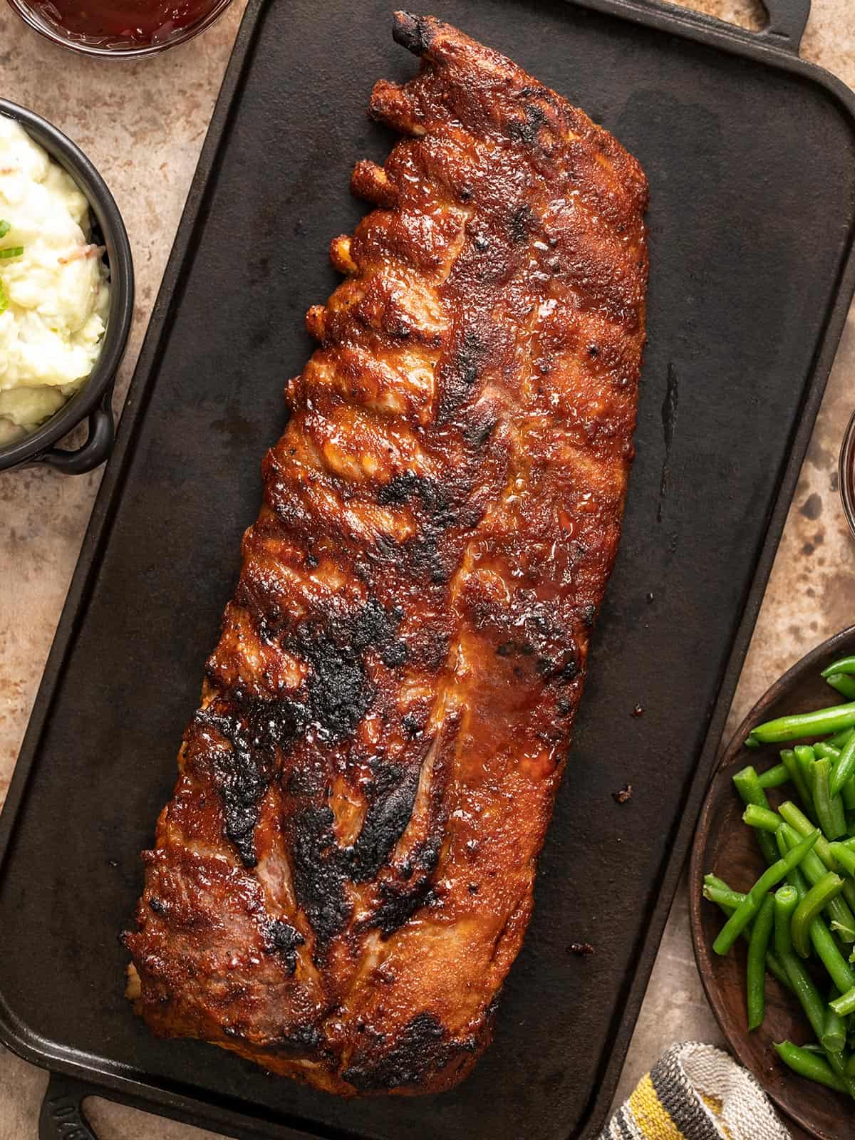 Baked ribs on a black plater.