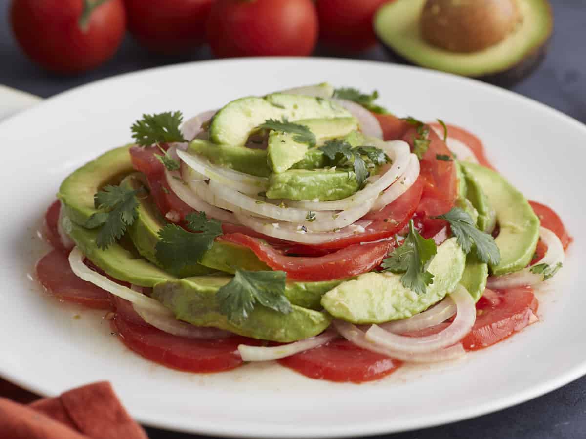 Side shot of Ensalada de Aguacate on a white plate.