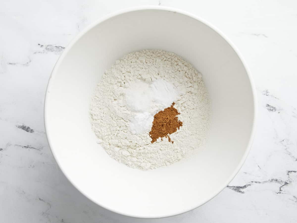 Dry Ingredients for zucchini muffins in a large white bowl.