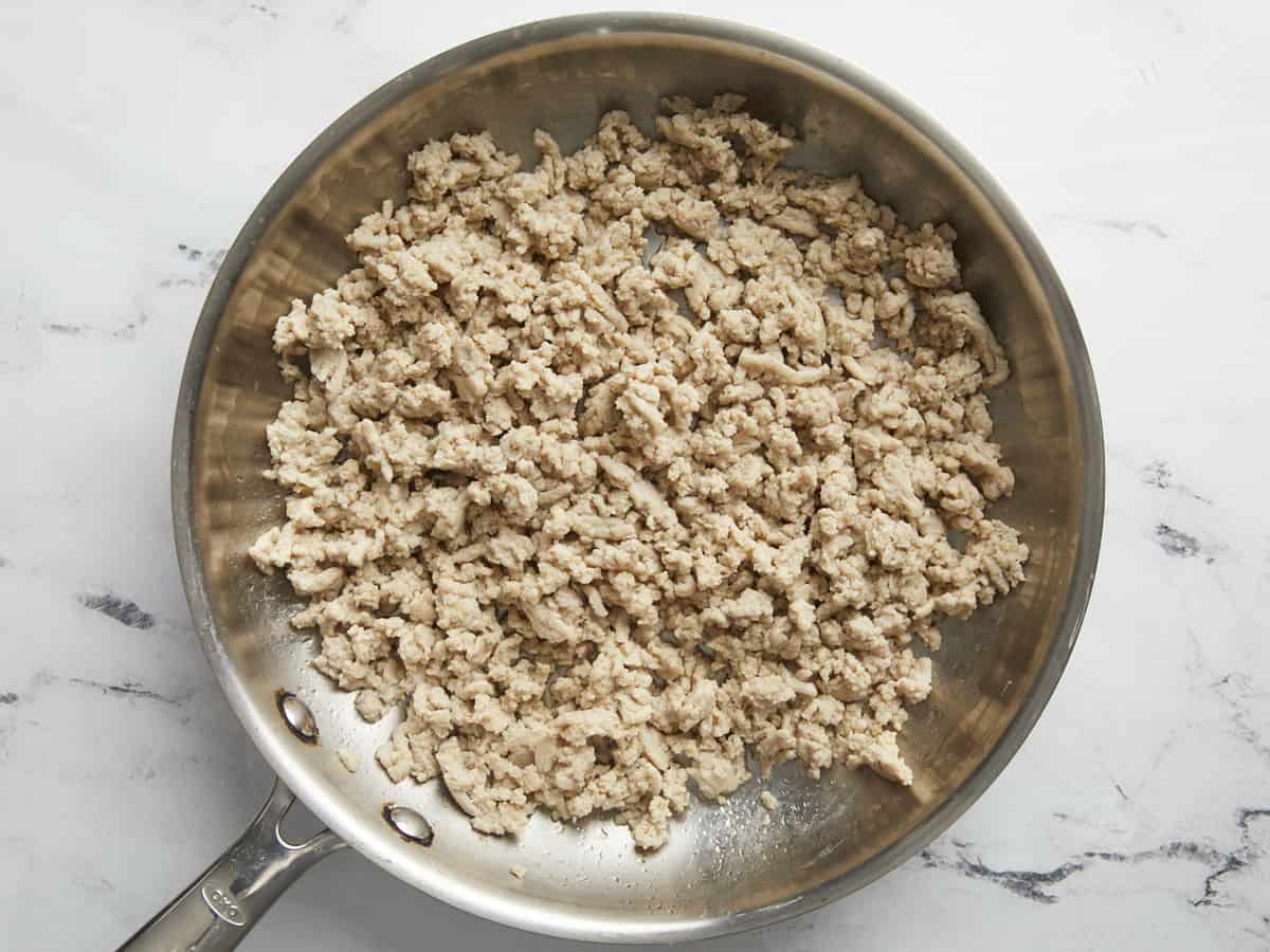 Cooked ground chicken in a large stainless steel skillet.