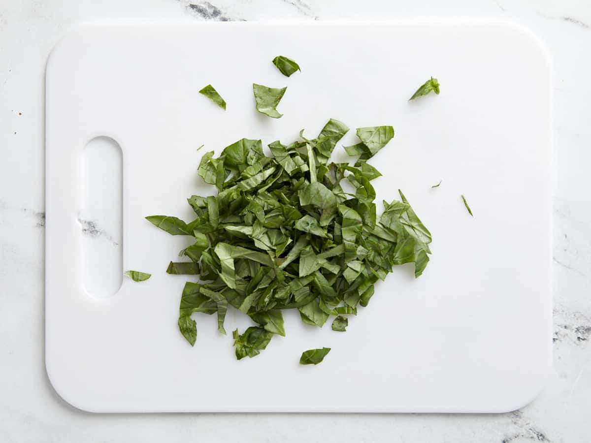 Chopped basil on a cutting board.