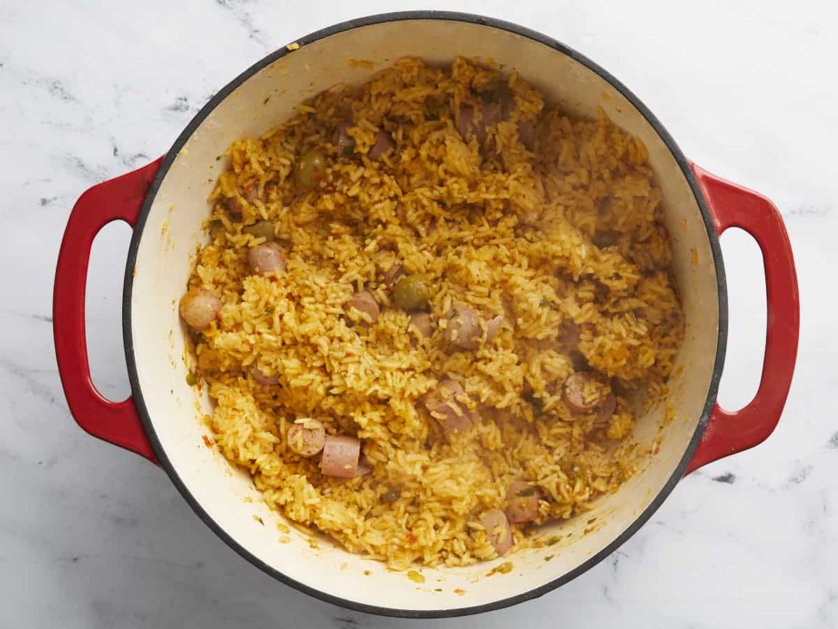 Overhead shot of Arroz Con Salchichas in a red Dutch Oven.